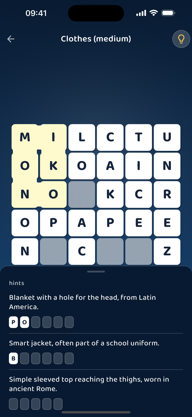 The hint sheet open under the board: each clue gives the word's meaning, with boxes for its letters and the first ones filled in.